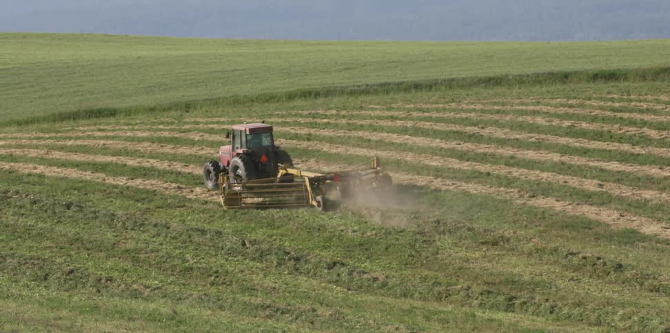 Tractor plows in the field pulling machinery