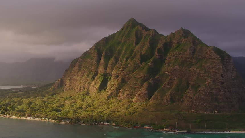 Mountain ridge along the coast under a dark cloudy sky