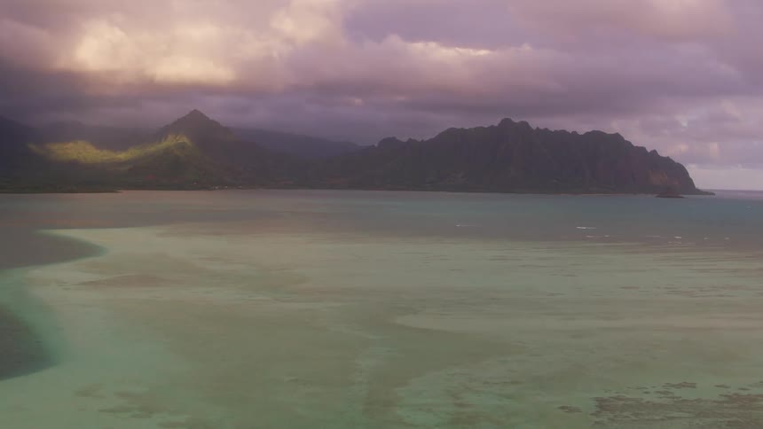 Sunlight peaks through dense clouds over the coast