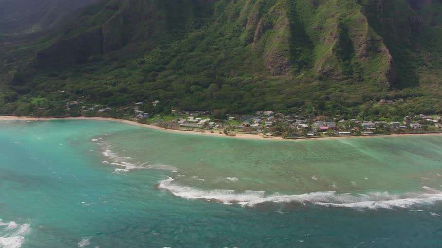 Aerial view of a small coastal town near a mountain