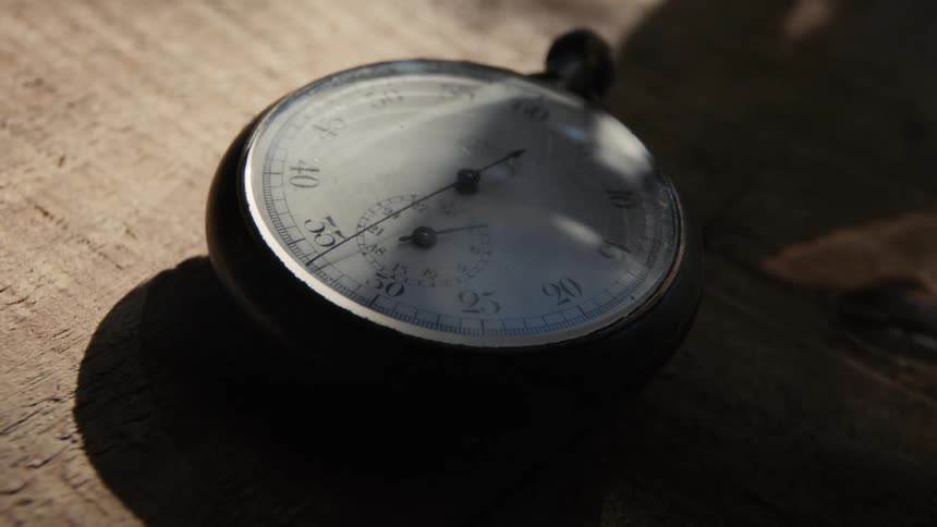 A stopwatch sitting on a table with sunlight