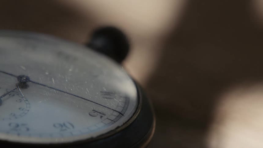 Close up of the dial of a vintage stopwatch chronometer over a table