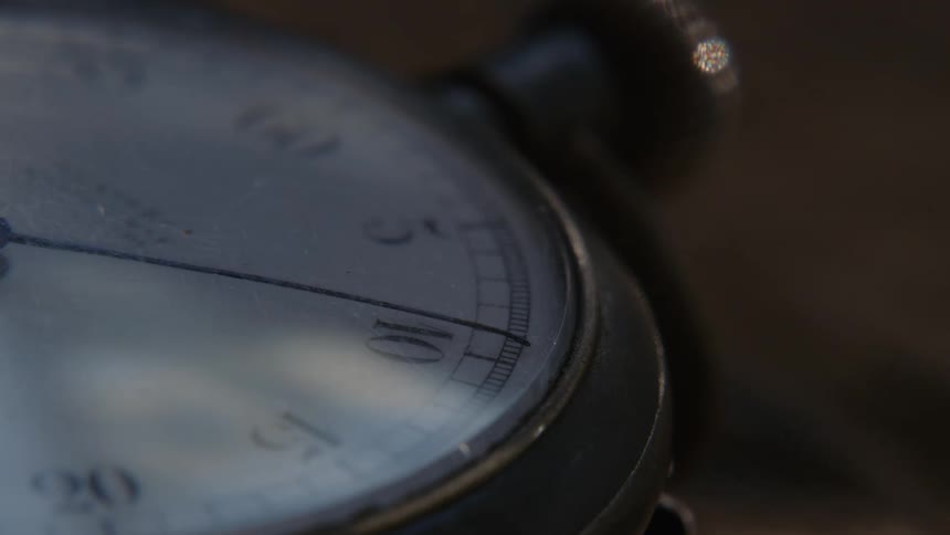Close up of the dial of an analog chronometer resting on a table