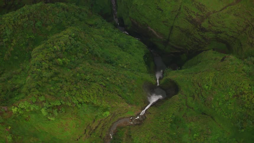The waterfall is pouring over the mountains