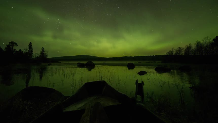 Northern lights illuminating the winter sky above a freezing lake