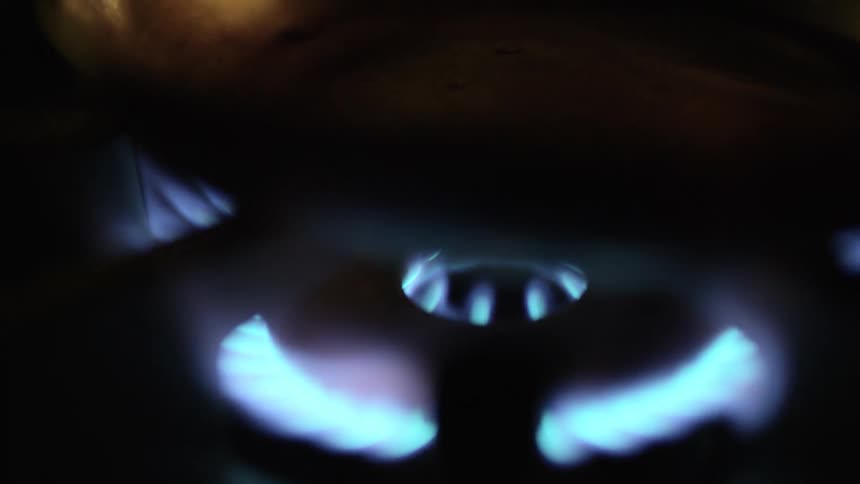 Iron pan over the blue flames of a gas kitchen range
