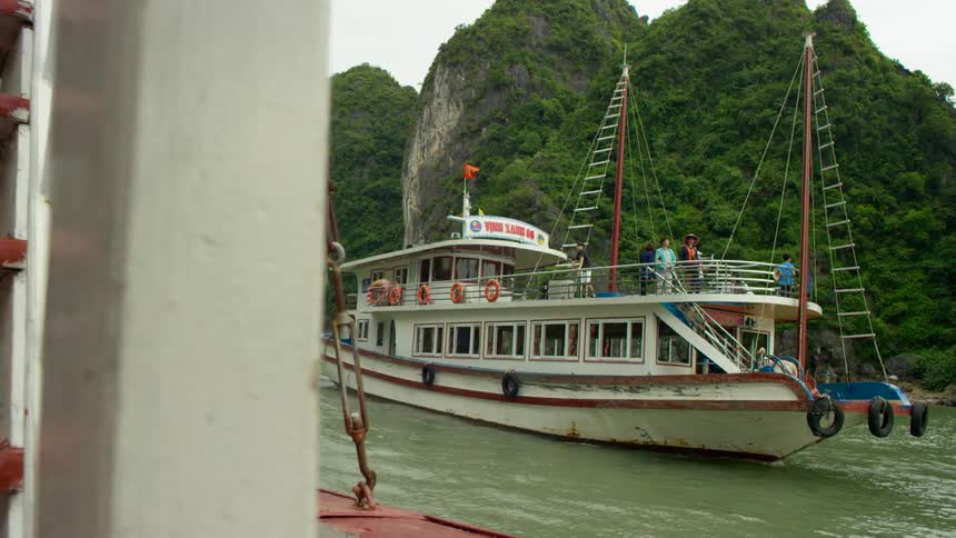 Two ferries traveling along a river on an overcast day