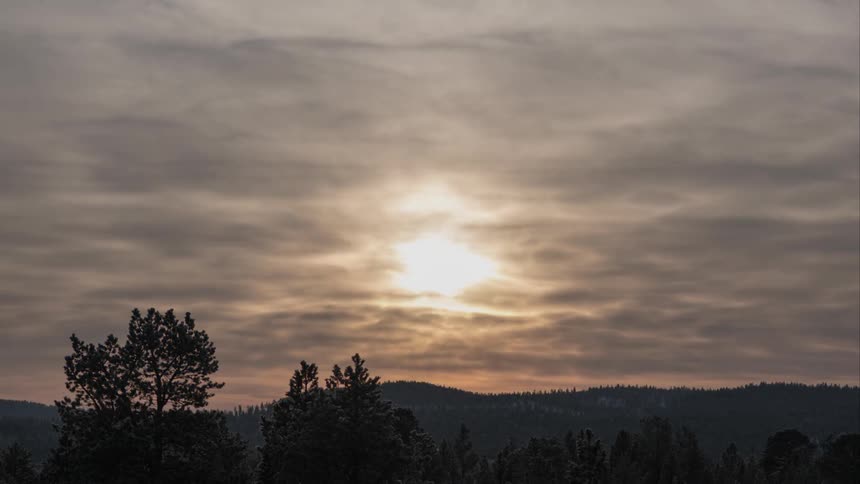 Time lapse of clouds passing over hilly forest