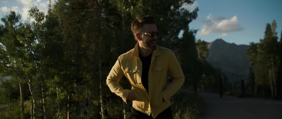 A man is walking by the forest laughing