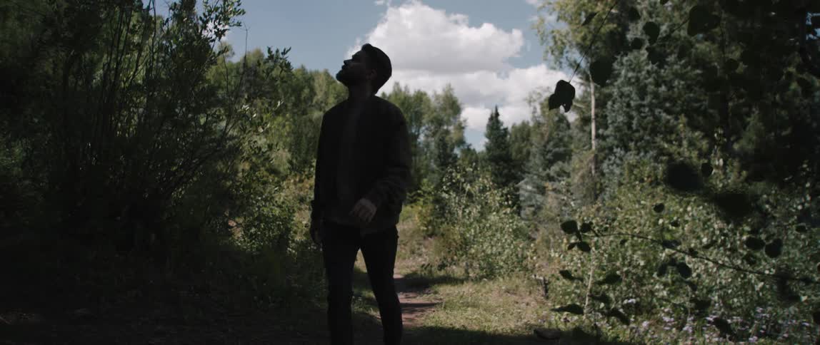 A man is hiking through the forest