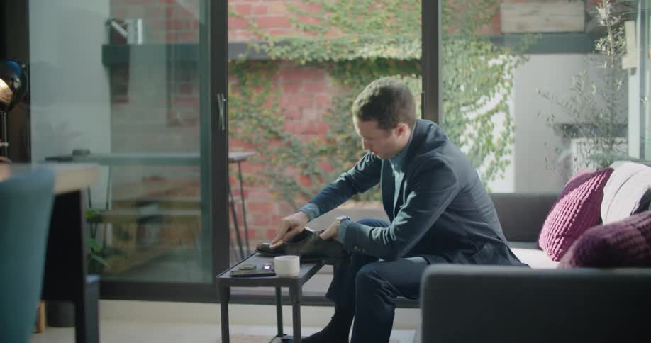 A man is polishing his shoes at home