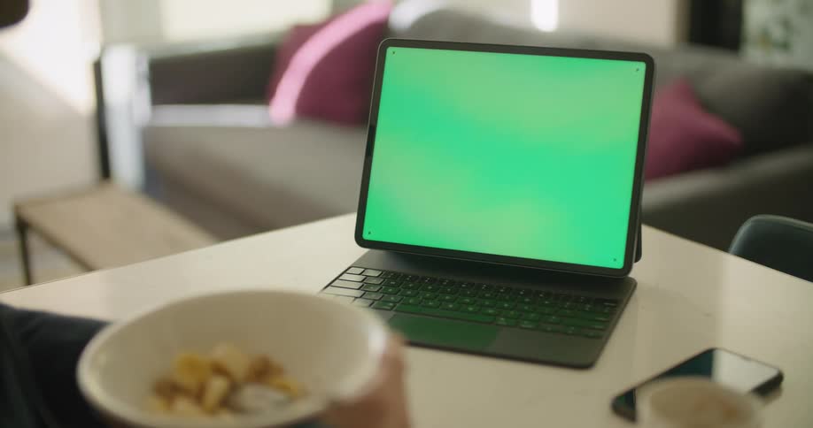 A person is sitting with a bowl by the tablet