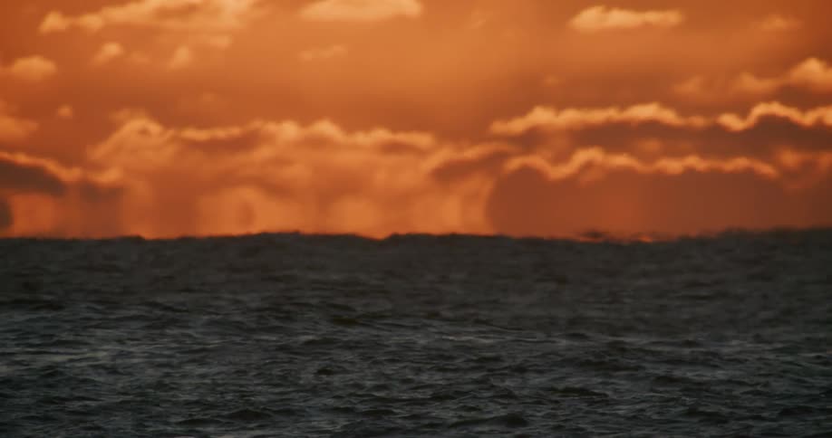 The sun is rising on the ocean