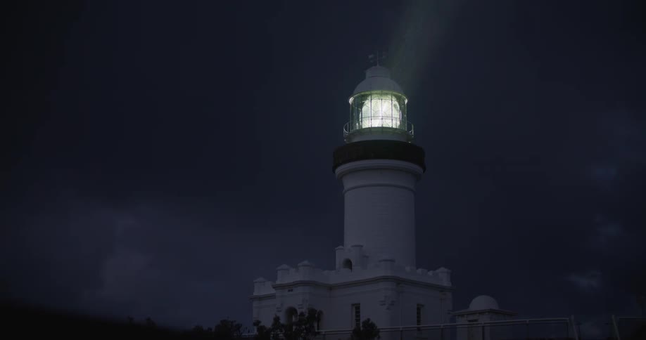 A bright spotlight spins in the tower of a lighthouse