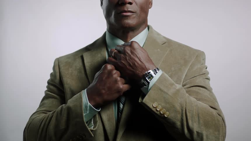 Man in suit straightens his tie