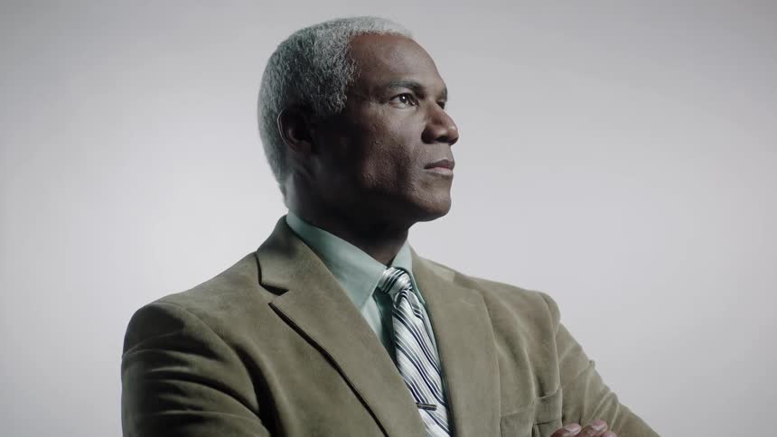 A man in a brown suit looks up