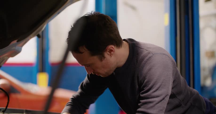A man working on an engine with a wrench