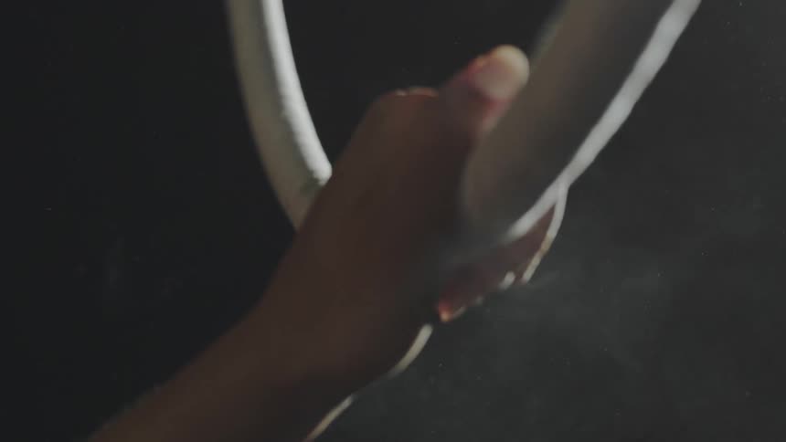 A gymnasts hand grabs a ring