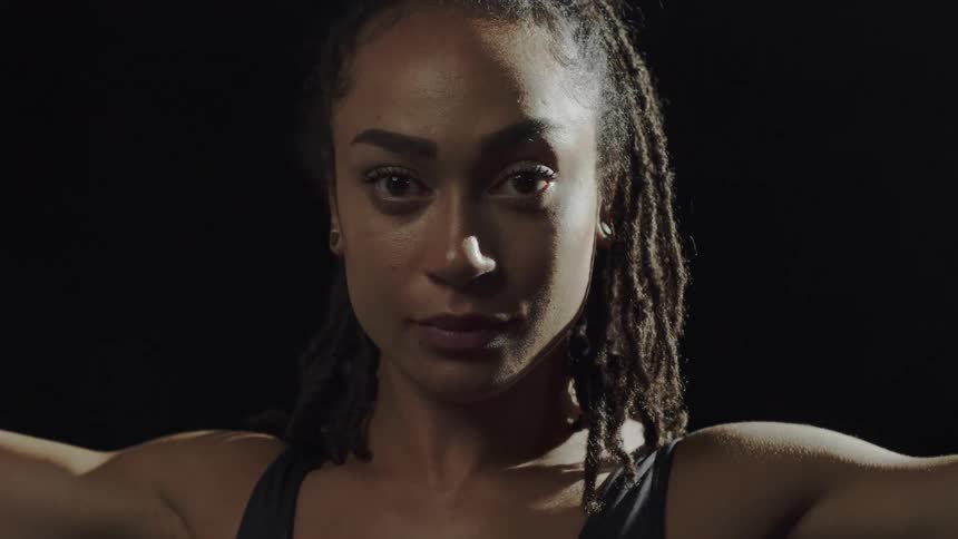A gymnast standing up next to a ring