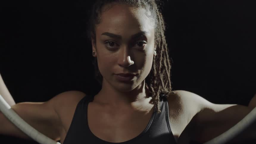 Gymnast with arms through large acrobatic hoop turns to look forward