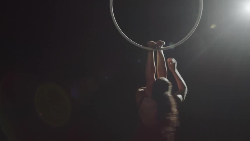 A woman is doing gymnastics on a ring on stage