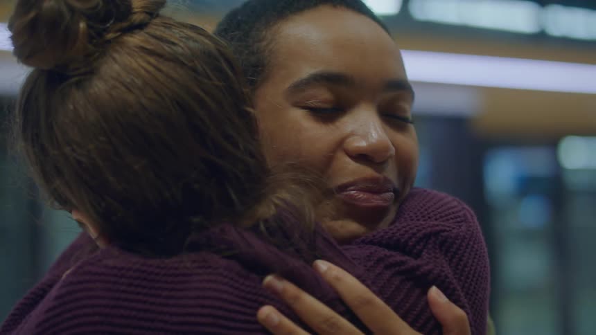Two women hug and greet each other
