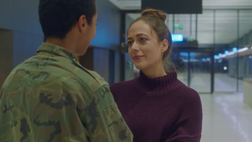 Happy woman cries while hugging a friend on an airport terminal