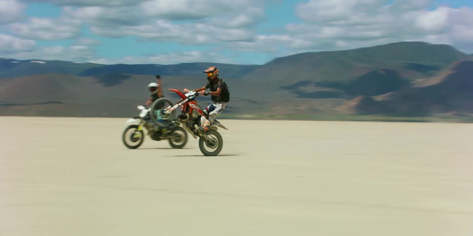 A group of people riding motorcycles in a dry lake bed