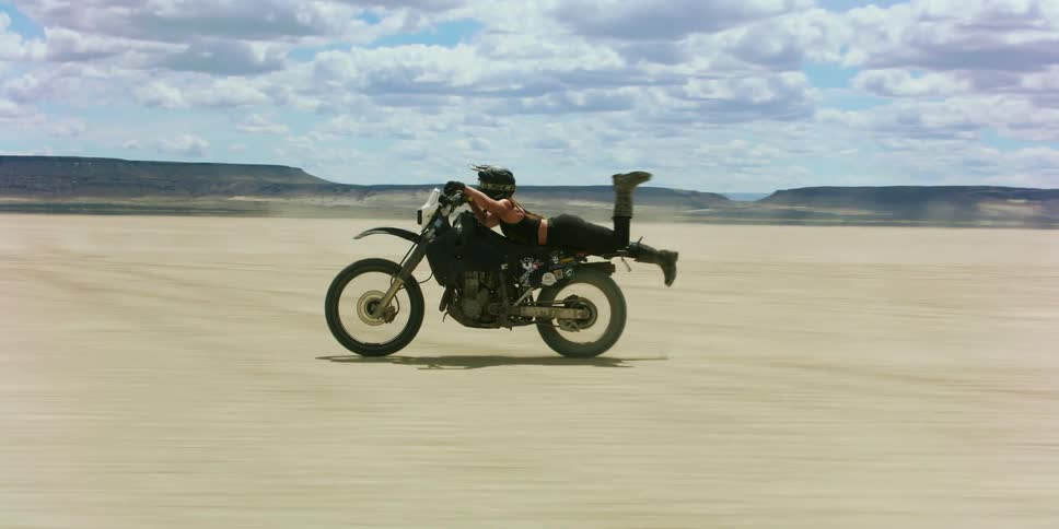 A group of people ride small motorcycles through a desert area