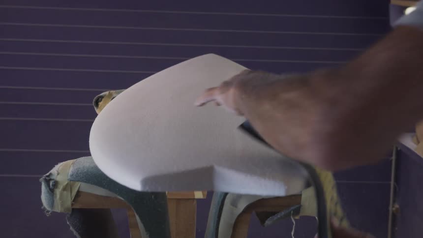 A man making furniture sands it