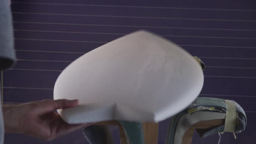 An employee sanding a surfboard