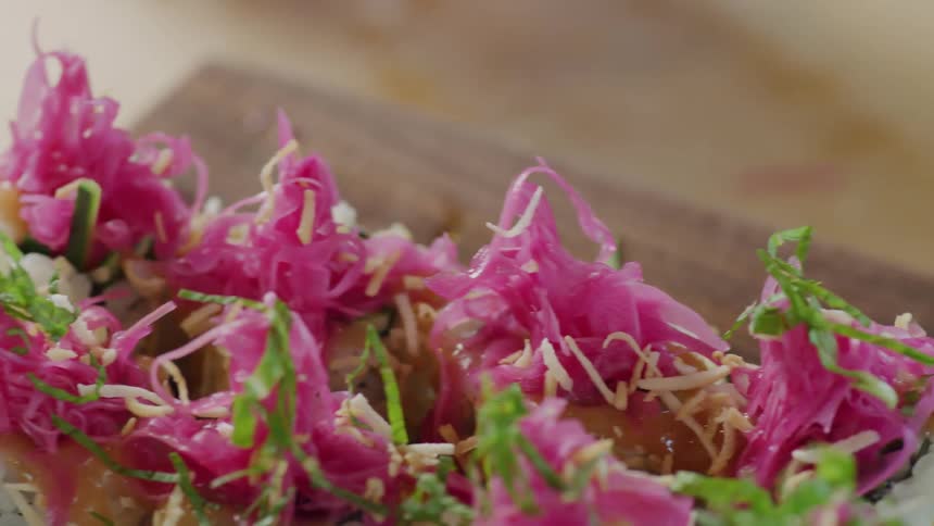 A chef adding garnish to a plated meal