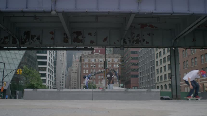 People skateboarding under a bridge