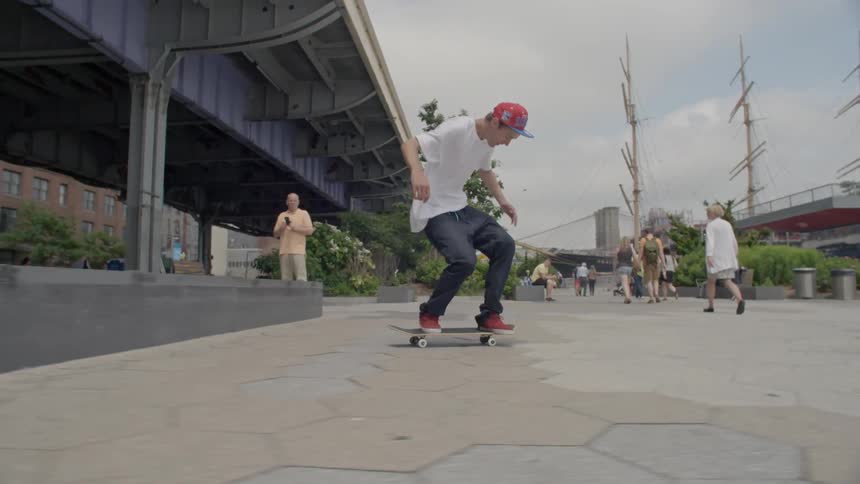 A person in a white shirt skateboards