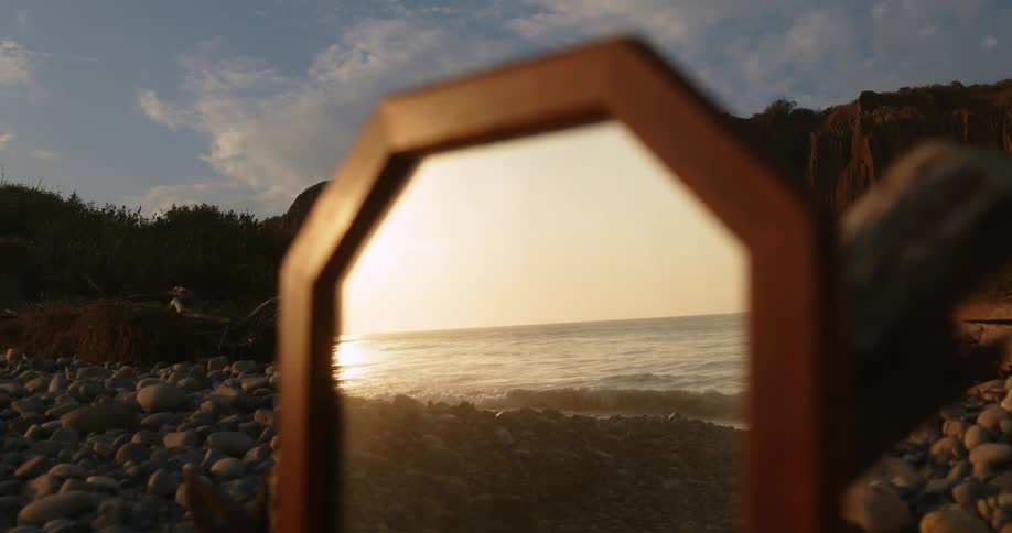 A mirror on the coast reflects the ocean and horizon