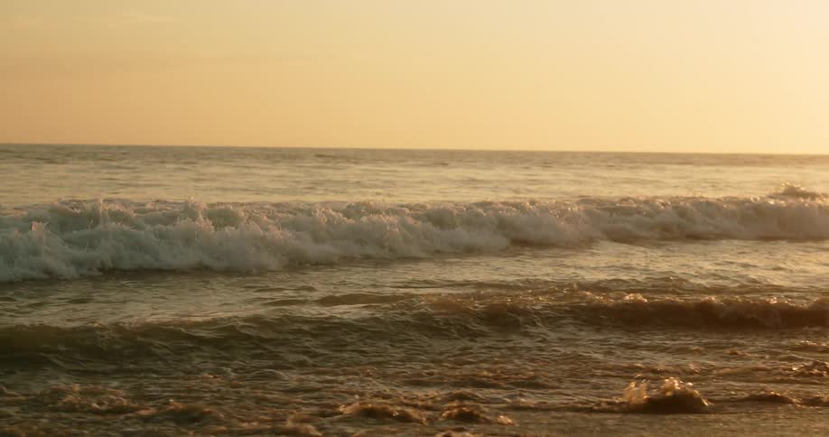A wide shot of a wave at a beach