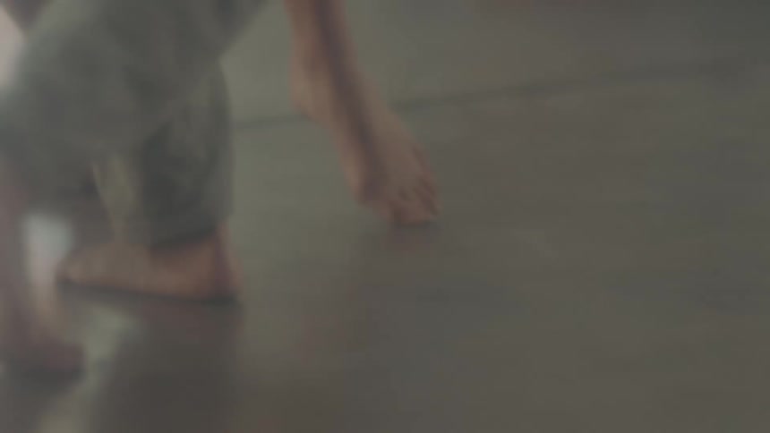 A pair of dancers slowly takes steps as the practice their dance moves