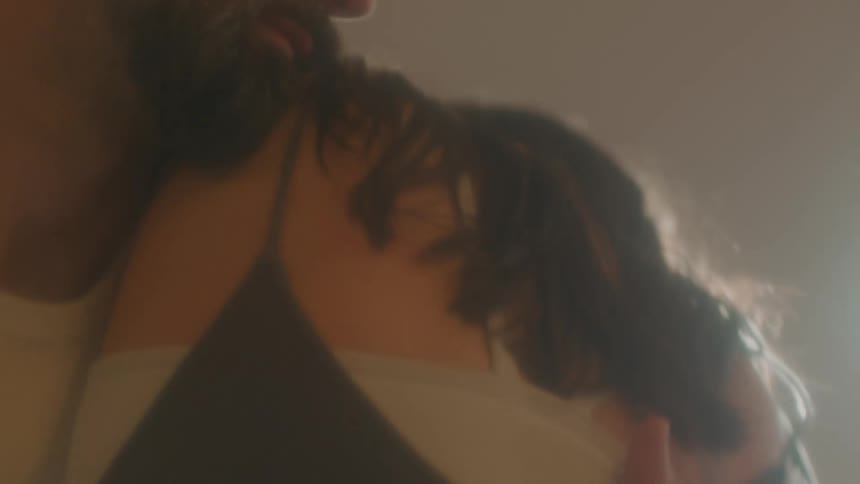 A man and a woman in a room dancing with a wall and doorway in the background