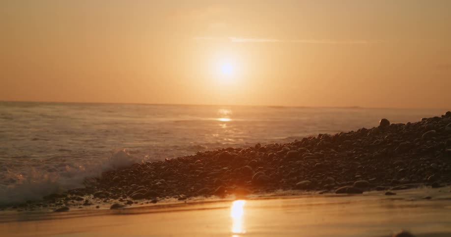 Waves crash onto the beach at sunrise