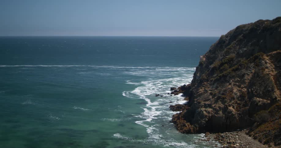 Waves gently crashing on the coastal cliff near the ocean at daytime