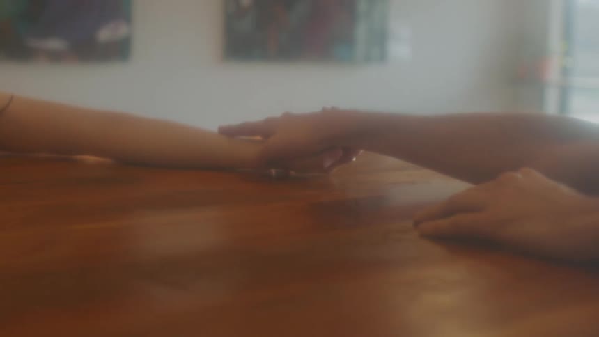 Two people grabbing hands in a fog