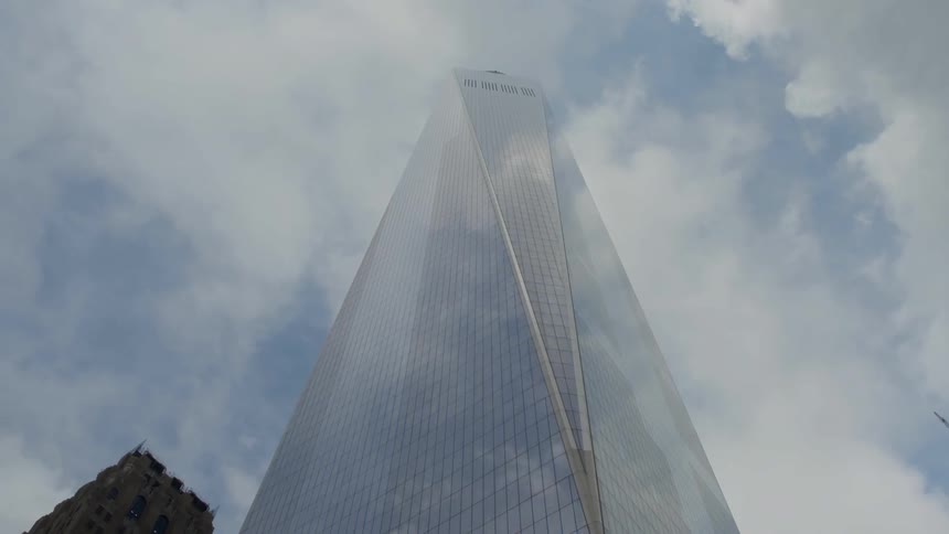 A skyscraper reflects the sky during the day