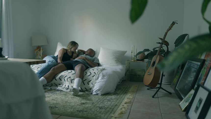 Young relaxed couple resting togheter on a bed in a room at home