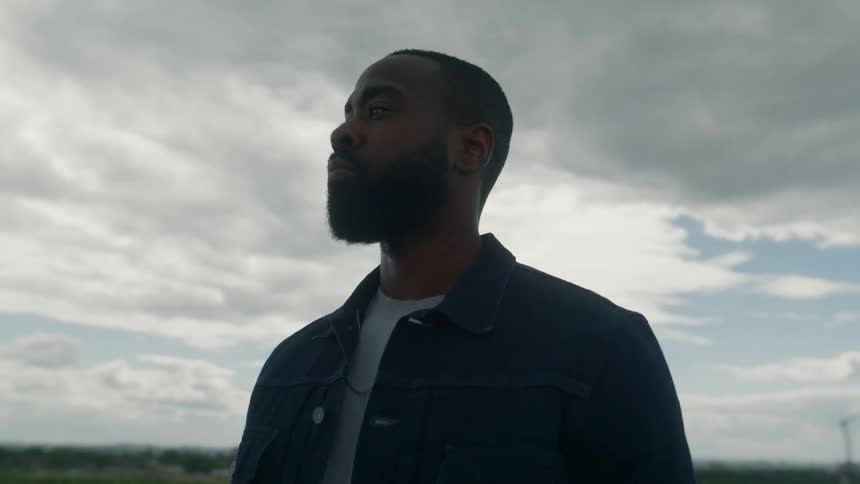 A man standing outdoors looking into the distance