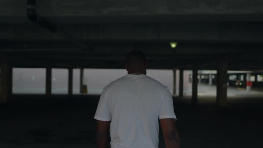 A man walks into an empty parking garage