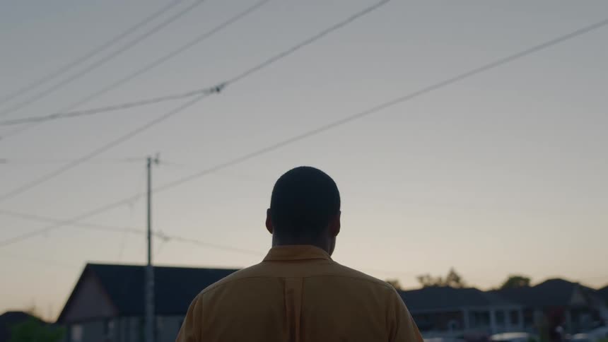 A man standing outside at sunset