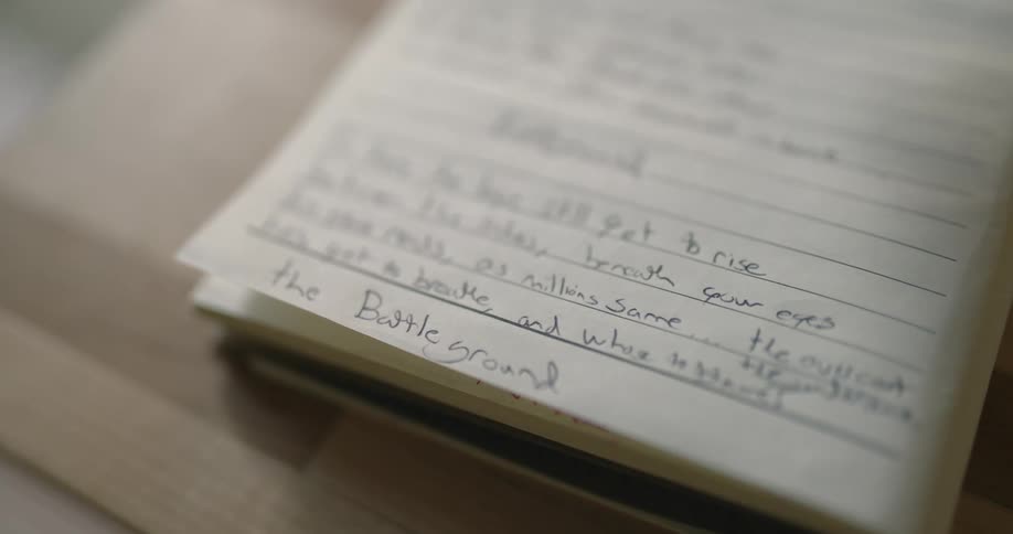 Handwritten notes fill a page in a small notebook