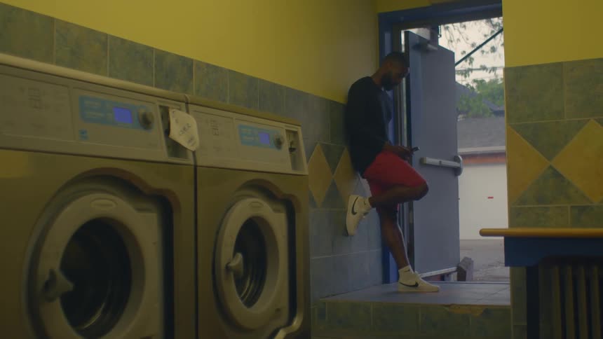 A man standing around in a laundromat