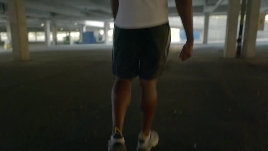 A man walks through an empty parking garage