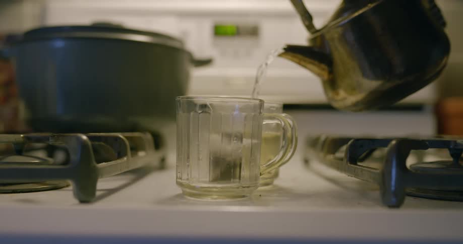 Tea being made in a cup in a kitchen